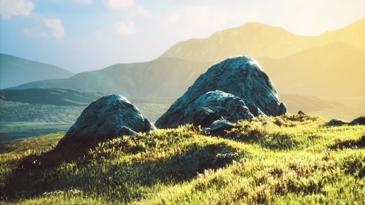 Natural landscape with large stones and green grass during golden hour