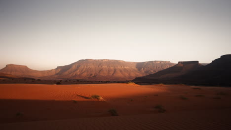 desert sunrise or sunset over red sand dunes and mountains