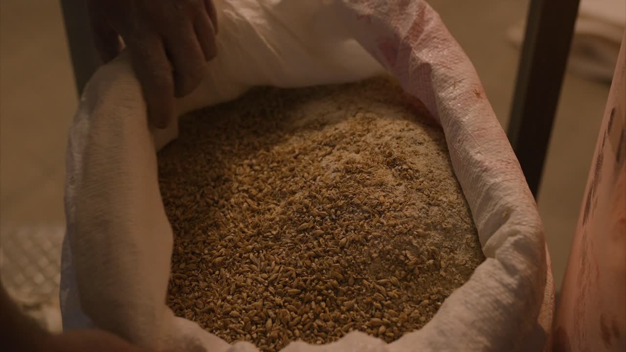 ground malt in a bag ready for brewing beer in a brewery handheld shot slow mo