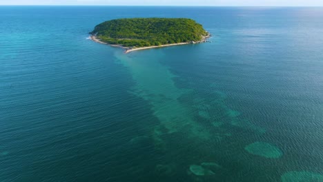 aerial view of a lush tropical island in the turquoise ocean