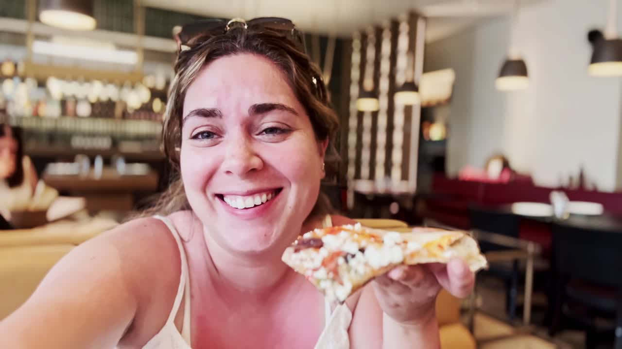 Donna Felice che Assapora una Fetta di Gustosa Pizza