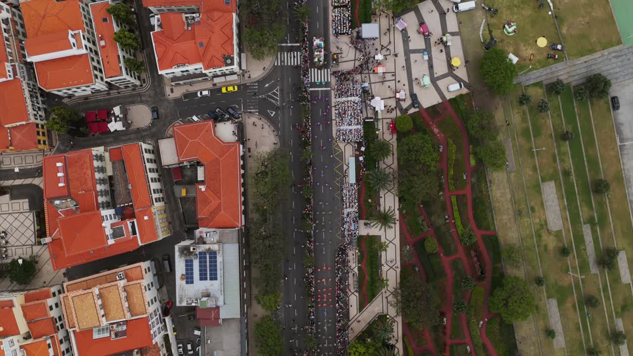 Aerial Birds Eye View Colorful alegoric float parade celebrating flower festival in Funchal, Madeira island, Portugal, with many people watching