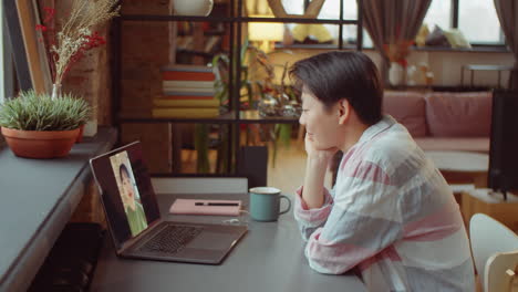 mujer asiática hablando en video llamada en la computadora portátil en casa