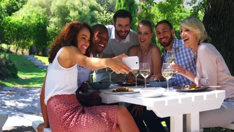 Amigos-Tomándose-Un-Selfie-Con-Un-Teléfono-Móvil-En-Un-Restaurante.