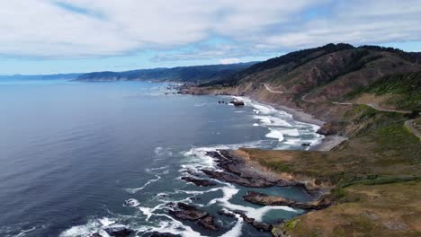 4k 30fps aerial footage oregon coast - static drone shot of us route highway 101 - ocean waves crash against oceanside rock formations as people road trip down the the royal road into north california