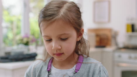 cute little girl with hands covered in chocolate licking fingers having fun baking in kitchen naughty child enjoying tasty treat at home
