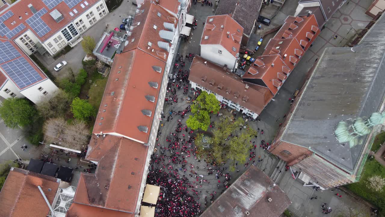 Birds Eye Aerial view : Bars of the Party Zone Square in old city Kaiserslautern fully crowded on Saturday night with FCK Kaiserslautern football Audience fans celebrating victory ( win ) with a beer