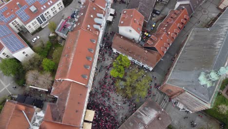 birds eye aerial view : bars of the party zone square in old city kaiserslautern fully crowded on saturday night with fck kaiserslautern football audience fans celebrating victory ( win ) with a beer
