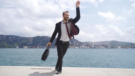 businessman dancing happily by the sea.