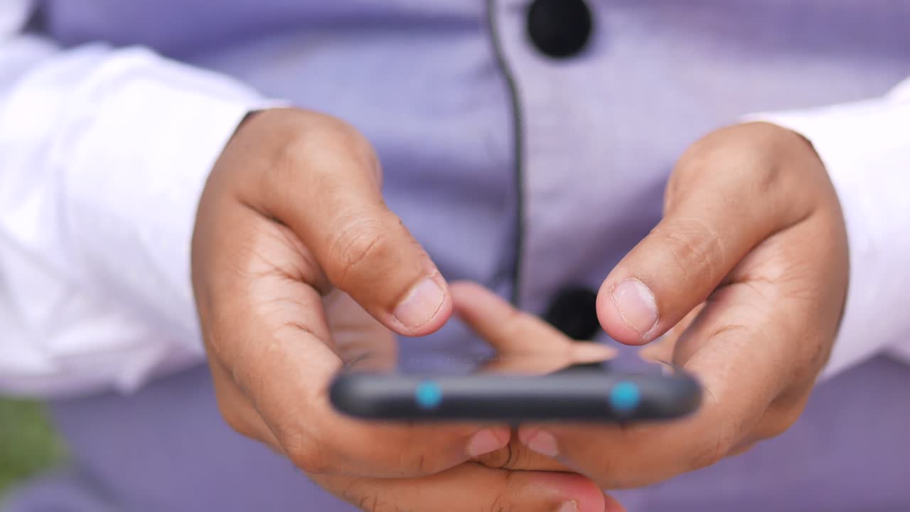 primer plano de la mano de un joven usando un teléfono inteligente