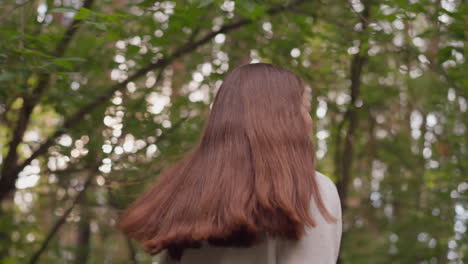 young lady athlete jogging in forest. red-headed woman engages in cardio-focused jog as part of professional fitness training routine surrounded by trees