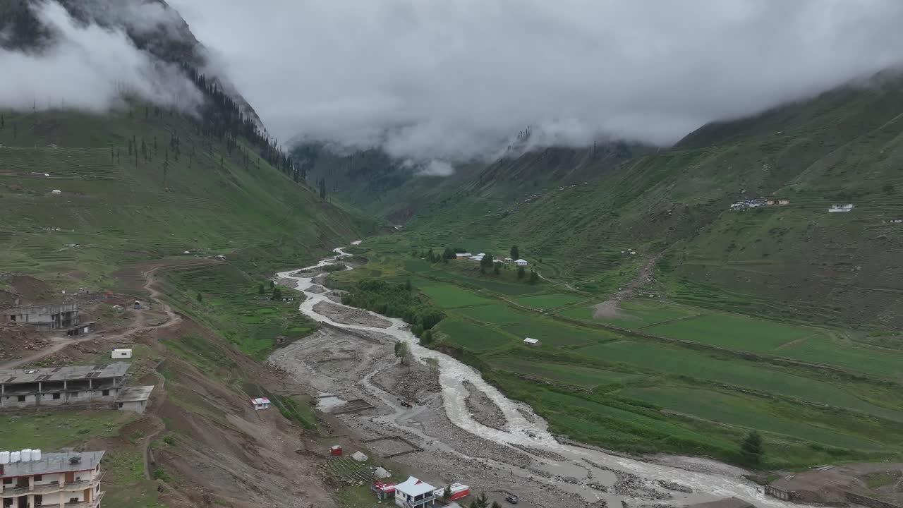 Bulutlu Bir Günde Pakistan'ın Kuzey Bölgesinde, Naran Batakundi'deki Yeşil Vadi Arasında Evler ve Yol Üzerinden Drone Görüntüsü