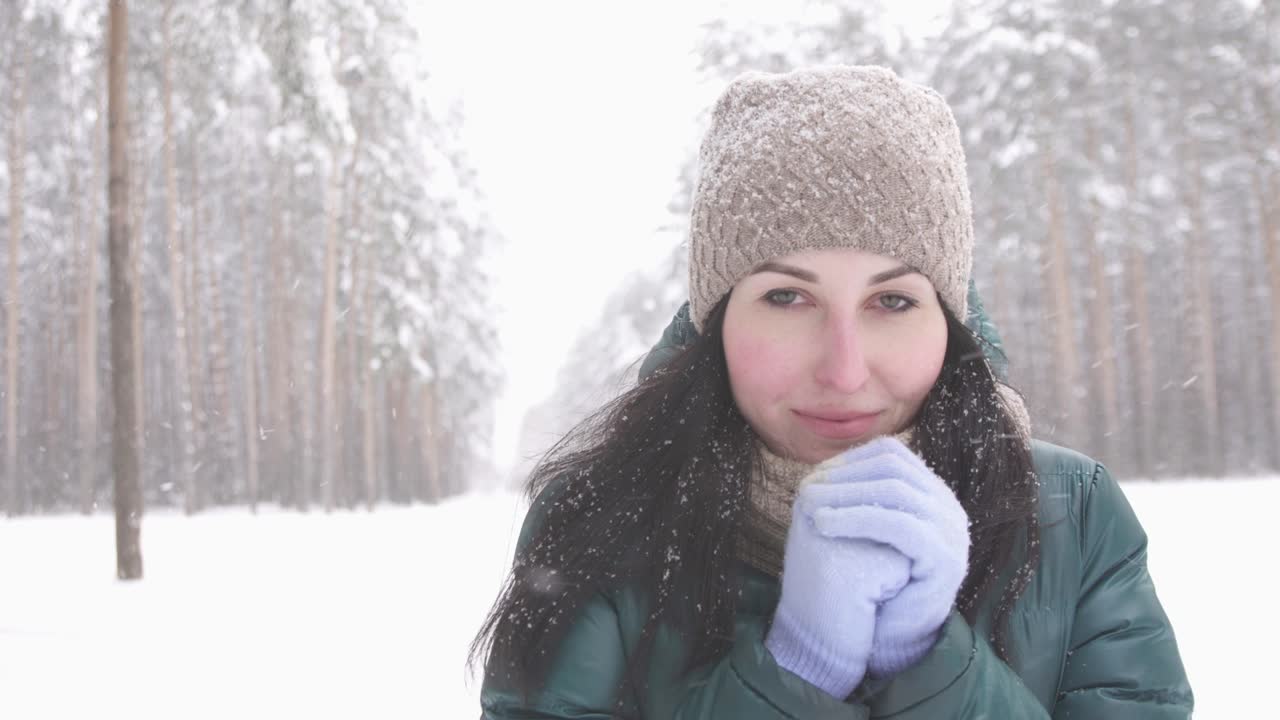 brunette girl in winter forest looking at camera, snow frost freeze