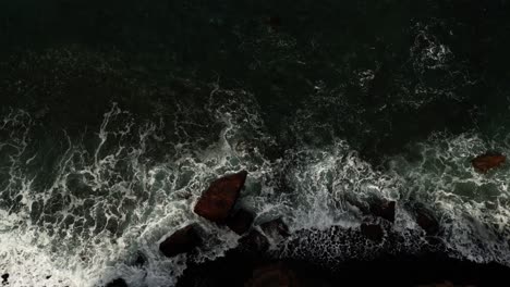 looking down as raging ocean waves crash against rocky coastline of ponta de sao lourenco, madeira