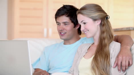 una pareja viendo un video en una computadora portátil