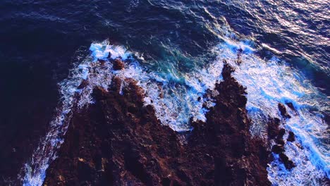 Overhead-Aufnahme-Von-Kleinen-Wellen,-Die-Sanft-Auf-Felsen-In-Los-Cristianos,-Teneriffa,-Spritzen