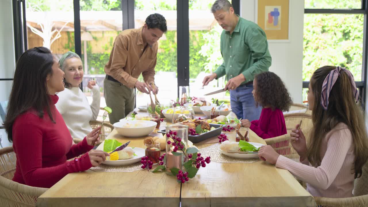 After table setup, family serving salad, carving roasted bird, celebrating meal at dining table