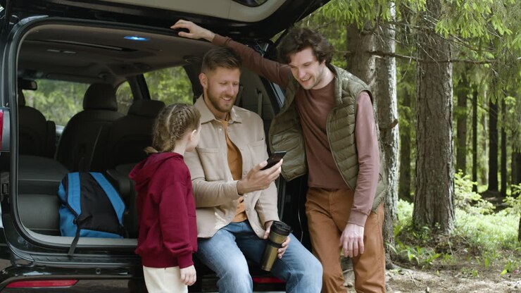 Famiglia che prende gli zaini dall'auto