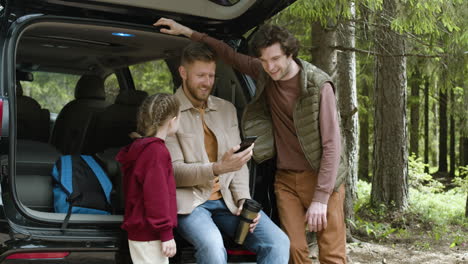 Family-picking-backpacks-from-car