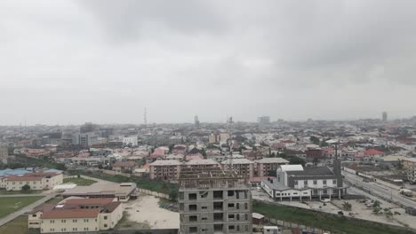 ascending above a construction site, a drone observes the dynamic activity, gradually revealing the vibrant cityscape of lekki, lagos, nigeria, capturing the synergy of urban development