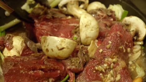 Korean-Food-Preparation---Person-Flipping-Meat-In-A-Pot---Close-up-shot