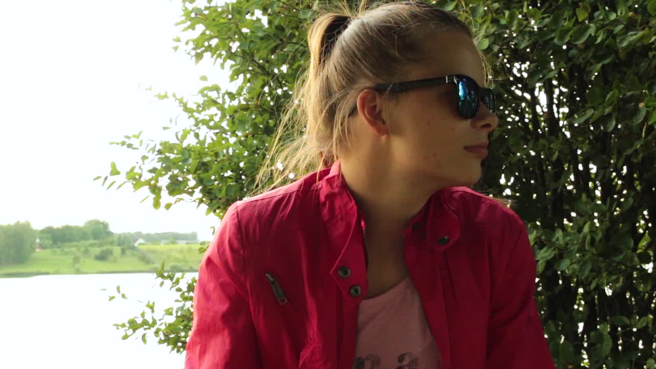 niña sentada afuera junto a un lago