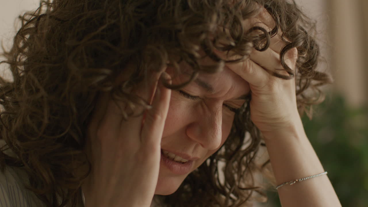 Close-up de Mulher Sofrendo de Dor de Cabeça Intensa e Estresse