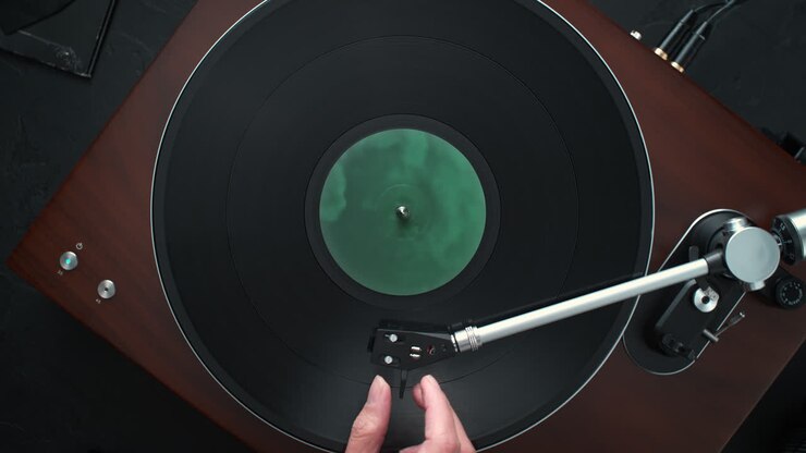 Turning off the Turntable - a Hand Lifts the Tonearm Using the Cue Lever, the Record Stops, and is Lifted off the Platter - Table Top View