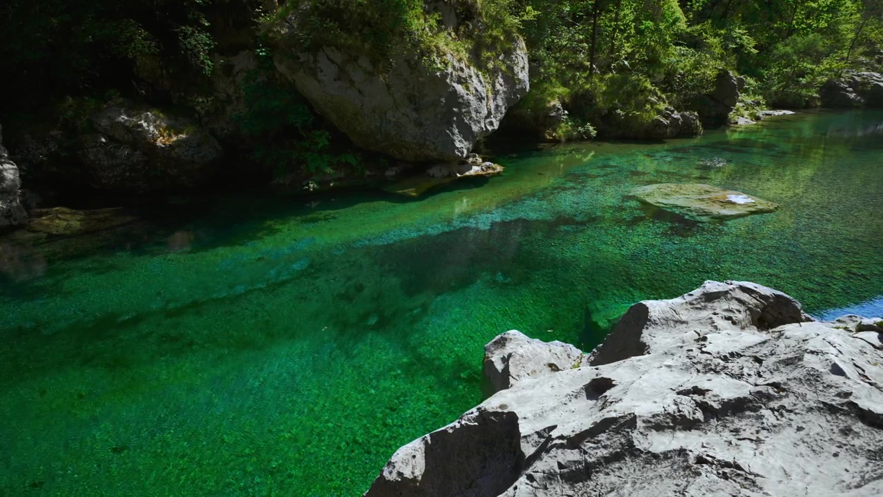 Acqua di montagna fresca e limpida in una pozza turchese trasparente tra rocce bianche alle Pozze Smeraldine