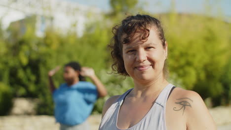 chica positiva del cuerpo estirando los hombros y mirando a la cámara