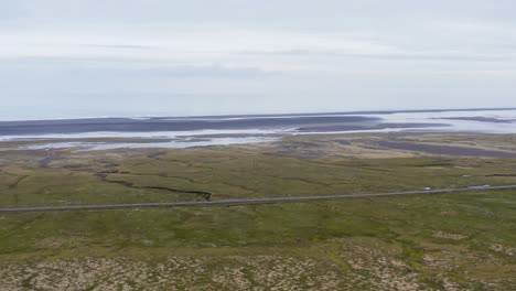volando más allá de la cresta de la roca, revelando la carretera de circunvalación de islandia y la costa del océano atlántico