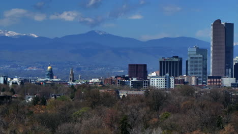colorado state capitol city park historic building downtown denver colorado aerial drone springtime summer sunny morning blue sky tall buildings skyscrapers city scape mountains pan right motion