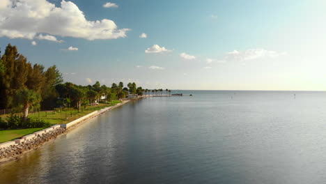 vuelo aéreo a baja altura pasando idílicas casas junto al mar hacia sandy point, pine island, florida