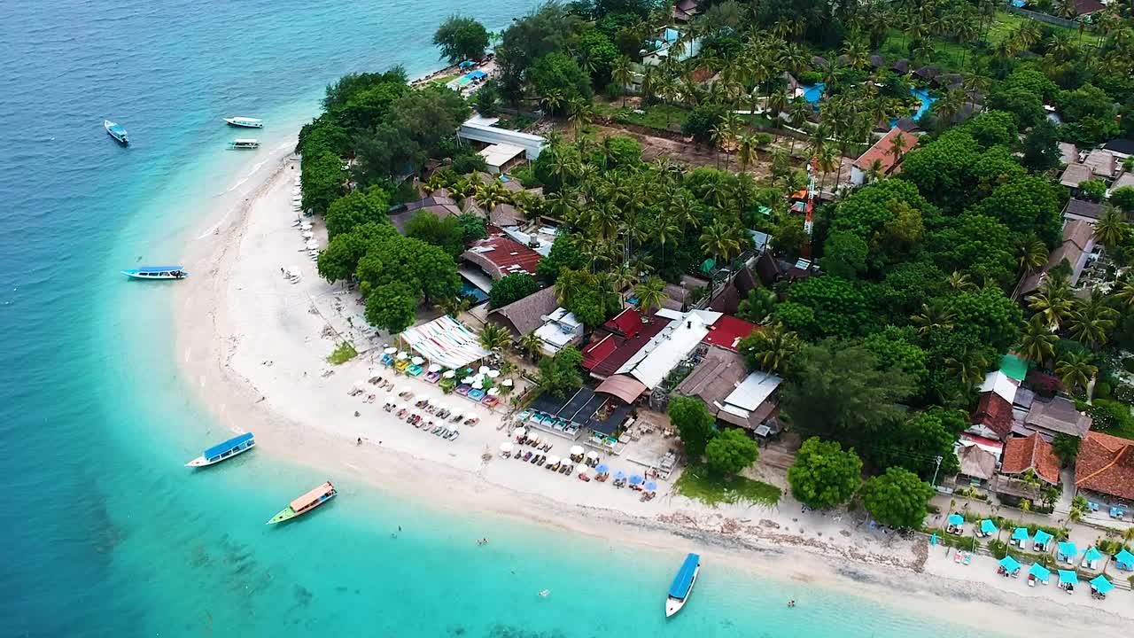 Inquadratura panoramica con drone delle splendide Isole Gili, Indonesia, con l'incredibile contrasto tra la vegetazione lussureggiante e la costa e le barriere coralline che circondano l'isola.