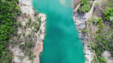 Volar-De-Arriba-Hacia-Abajo-Sobre-La-Vista-De-Un-Sitio-De-Construcción-De-Una-Mina-Con-Un-Gran-Río-Azul