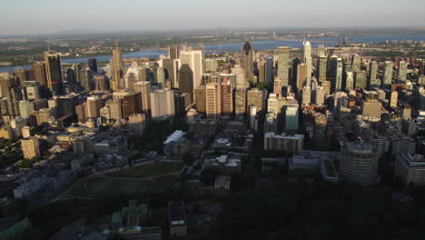 flying sideways in front of the metropolis of montreal, golden hour in canada - aerial view