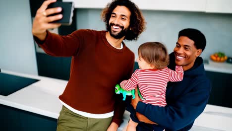 gay family selfie moment in a bright and modern kitchen.