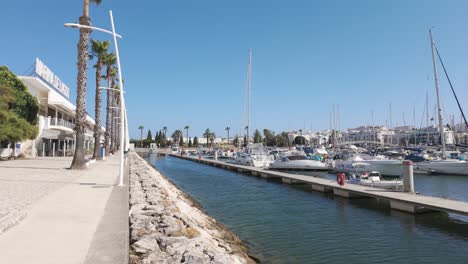 low-angle of lagos marina with boats docked on calm water and buildings in background