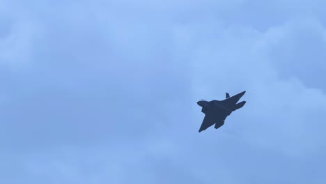 a jet fighter executes dynamic aerial maneuvers against a backdrop of cloudy skies, captured in smooth motion with steady camera work