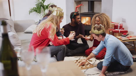 group of friends playing board games after enjoying christmas dinner at home