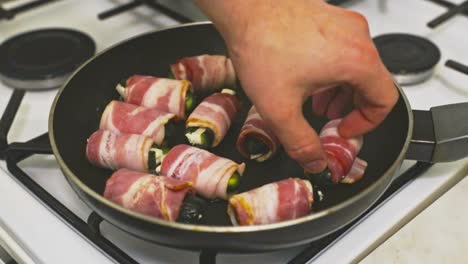 Putting-wrapped-mozzarella-stuffed-jalapeno-peppers-into-a-frying-pan