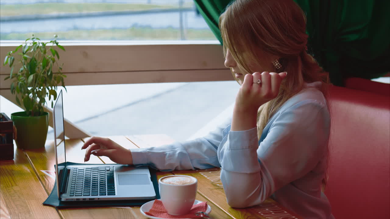 женщина работает на ноутбуке в кафе