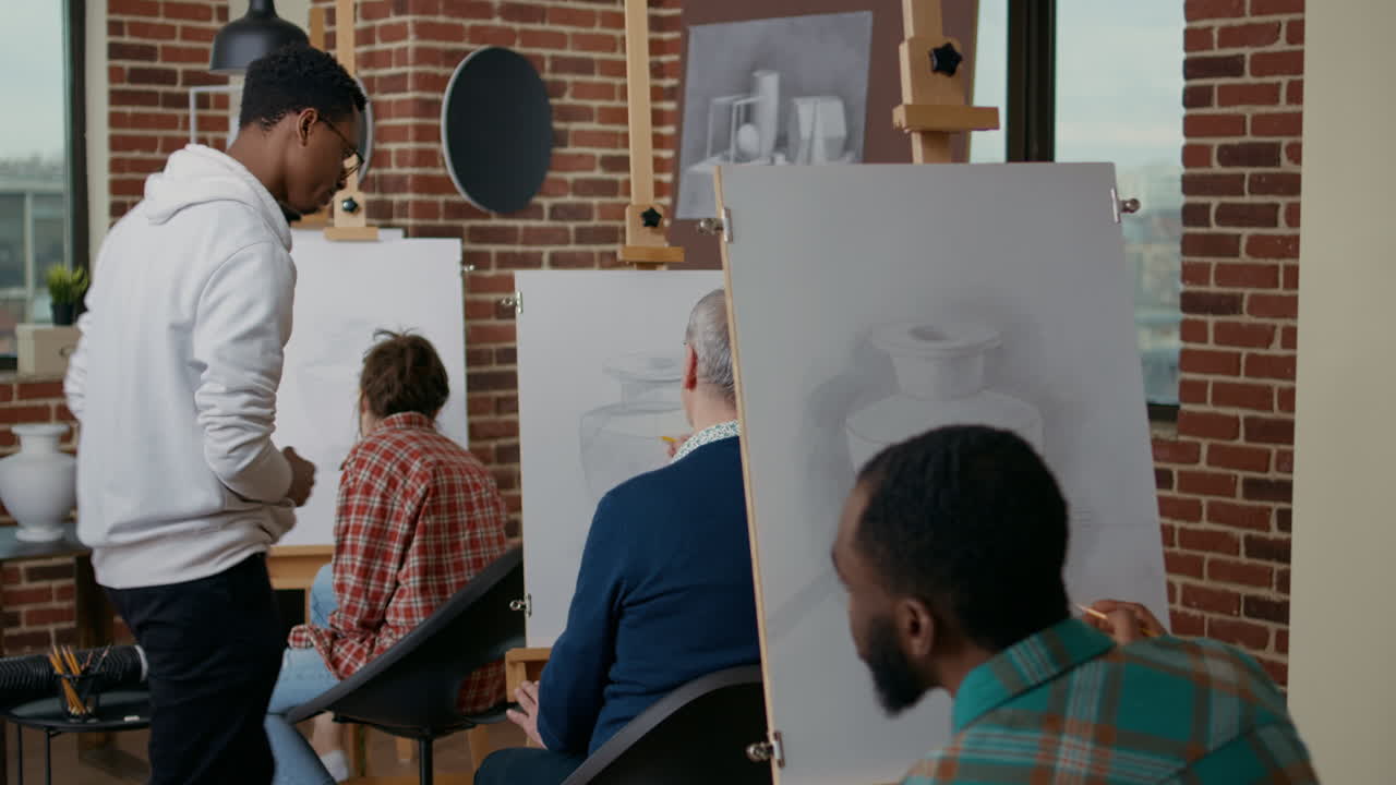 Young artist explaining drawing technique to elder person