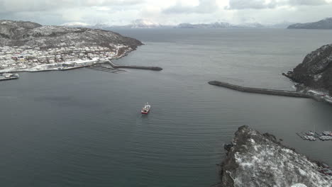 boat leaves skjervoy harbor heading towards fishing grounds in the arctic, drone