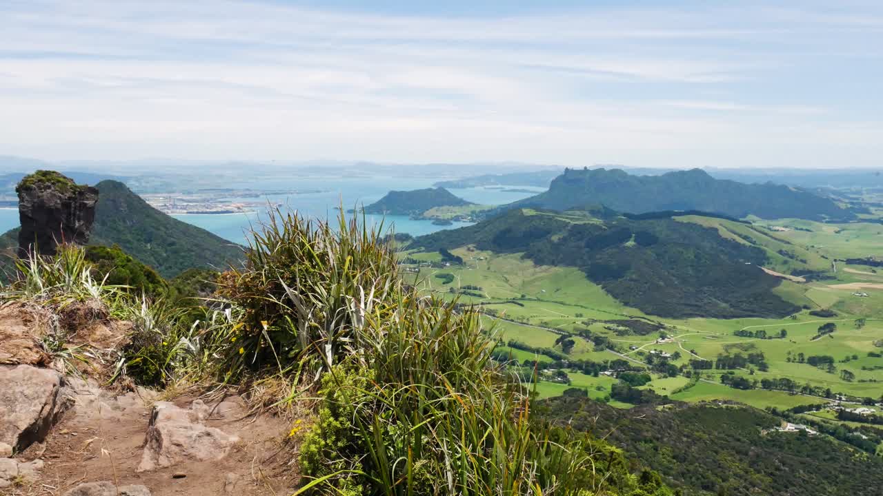 panorama aéreo tomado desde el punto de vista sobre el hermoso paisaje montañoso y el océano durante el día soleado - te whara track, nueva zelanda