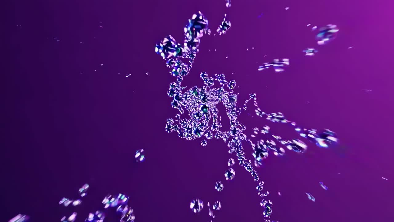 Dynamic video of water droplets captured from a low-angle, creating a mesmerizing, abstract pattern