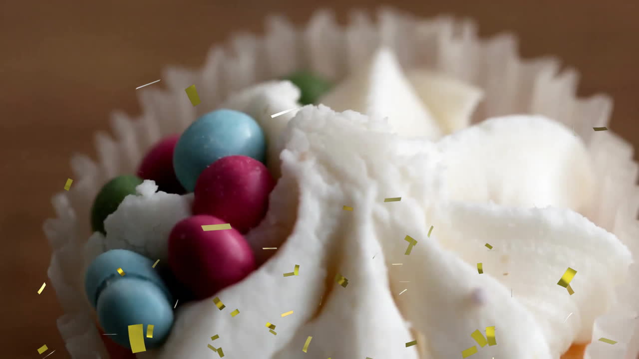 pastel con glaseado blanco y caramelos coloridos sobre la caída de la animación de confeti