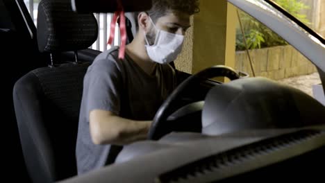 hombre con mascarilla quirúrgica desinfectando la dirección del camión, prevención covid-19