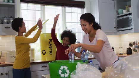 Mixed-race-lesbian-couple-and-daughter-cleaning-kitchen