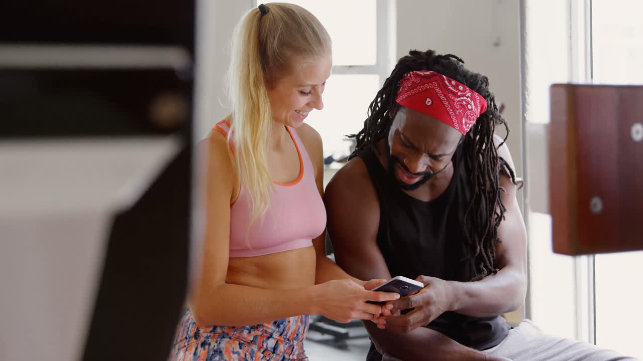 entrenador masculino y boxeadora usando teléfono móvil 4k